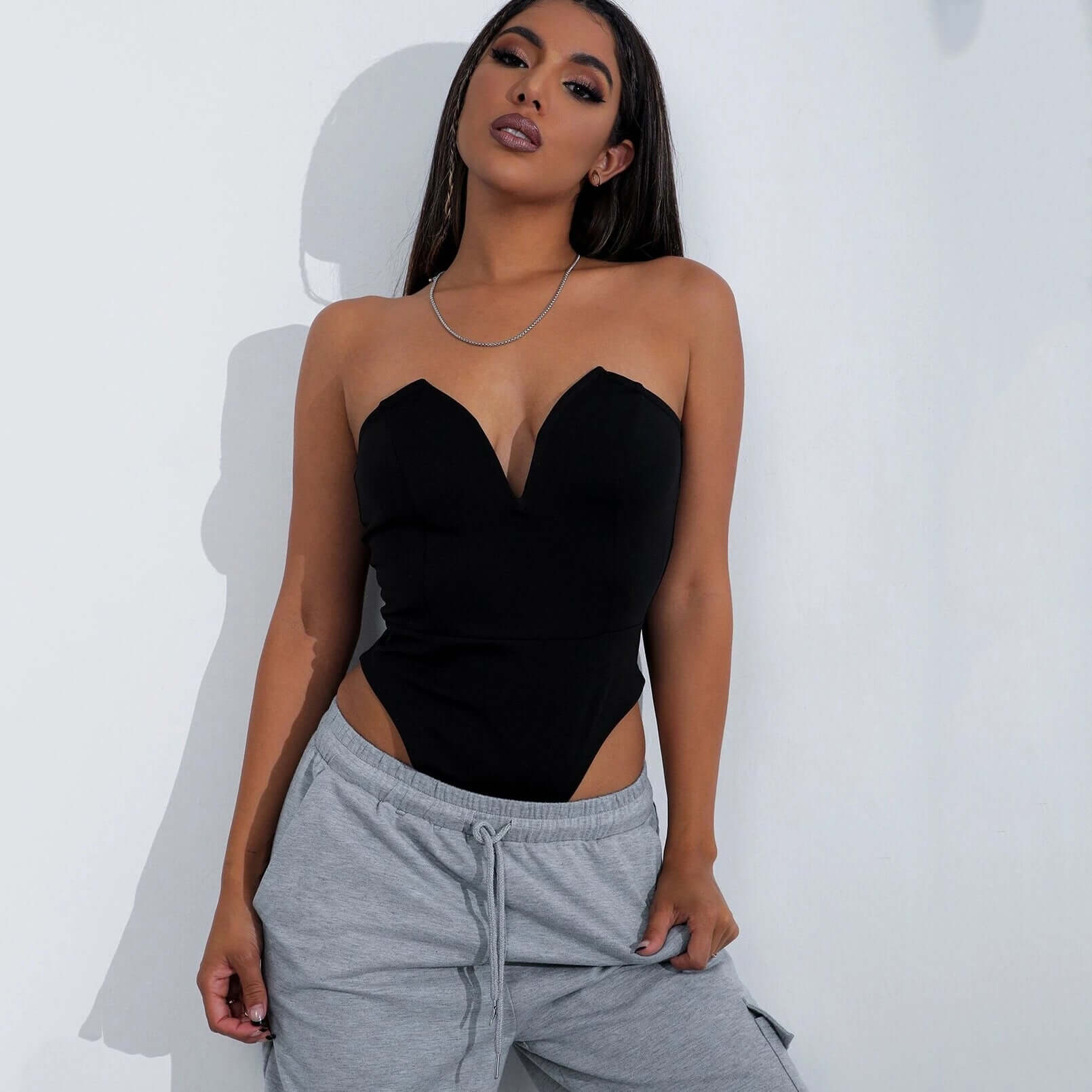 Sexy V-Chest One-Piece Tops Women Tight Bottoming Shirt Slim Slimming Onesies in black, paired with grey sweatpants.